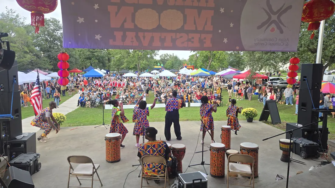 View from the stage as Academy youth dance and drum for a large outdoor crowd at the Harvest Moon Festival